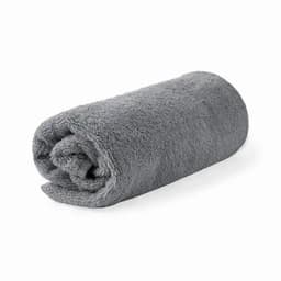 A rolled grey towel made of soft, plush fabric, showcasing a smooth texture. It has a simple, elegant design.