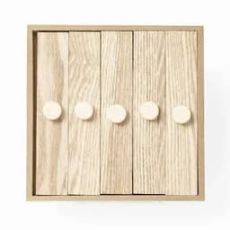 A wooden box with five slatted panels in light wood, each featuring a round, cream-coloured knob.