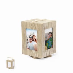 A wooden photo cube with two picture frames and a small lantern-like accessory. The wood has a light, natural finish.