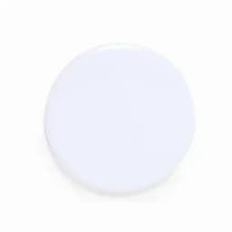 A round white product with a smooth surface, featuring a simple design and a logo.