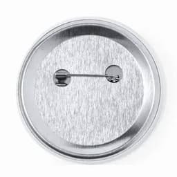 A silver metal badge with a safety pin fastening on the back. The surface has a brushed metallic finish.