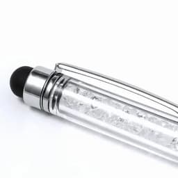 A pen with a clear body filled with sparkling crystals and a black top. It features a silver clip for easy attachment.