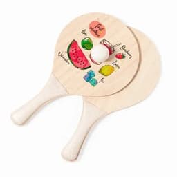 A set of wooden paddles featuring colourful fruit illustrations and a white ball. The paddles have a simple design.