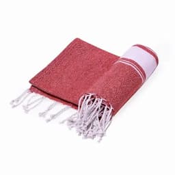 A red and white woven towel with tassels, folded to display its textured fabric.