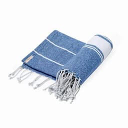 A rolled-up blue towel with white stripes and fringe detailing, featuring a small branded label.