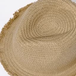 A straw hat in a natural beige colour with a fringed brim and a smooth, rounded top.