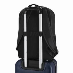 A black backpack featuring adjustable straps and a trolley handle, resting on a blue suitcase.
