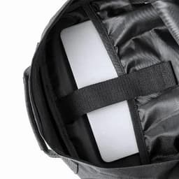 A bag interior featuring a black lining and a padded section for a laptop or device, secured with a strap.