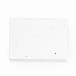 A white rectangular slab with small black specks, featuring a smooth surface and a clean appearance.