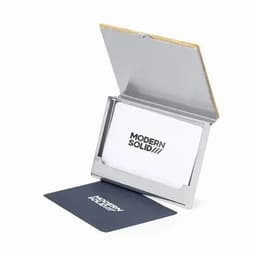 A business card holder with a metal finish and a wooden back, displaying business cards inside.