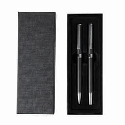 A gift box containing two black pens with silver accents, set against a black background.