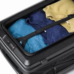 A suitcase with folded sweatshirts in blue, navy, and yellow, neatly organised inside a black case.