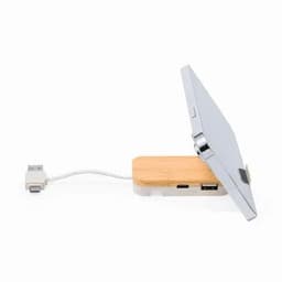 A wireless charging station with a bamboo base and a silver charging pad, featuring USB and USB-C ports.