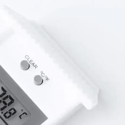 A digital thermometer with a clear display and grey buttons, set against a white background.