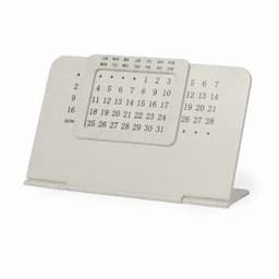 A desk calendar in a cream colour, featuring a simple design with numbers and days of the week, and a stand.