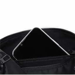 A black bag with a zippered pocket containing a smartphone. The interior is lined with a dark fabric.