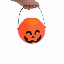 An orange pumpkin-shaped candy bucket with a smiling face and a black handle.