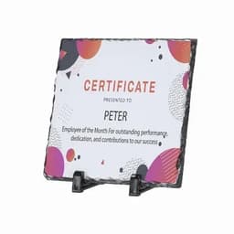 A certificate displayed on a textured slate plaque, featuring vibrant shapes and a black stand.