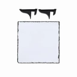 A slate serving board in a square shape with two black serving clips on top. It has a textured edge.