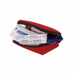 A red first aid kit containing bandages, scissors, and other medical supplies, all neatly organised inside.