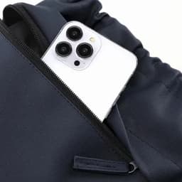 A navy pouch with a zipper, featuring a white smartphone partially visible inside.