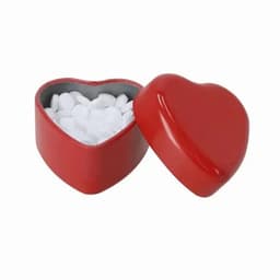 A red heart-shaped box with a lid, containing white circular mints inside.