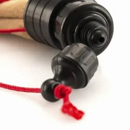 A drink bottle nozzle in black, with a toggle and red cord, featuring a textured grip for secure handling.