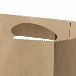 A brown paper bag with a handle and scalloped edges, featuring a simple, minimalist design.