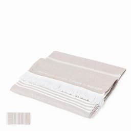A woven beige towel with white stripes and fringed edges, displayed folded flat. It has a logo on one side.