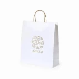 A white shopping bag with a gold logo featuring a floral design and two handles.