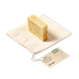 A solid soap bar in a natural shade, presented on a small cloth pouch with a tag.