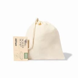 A drawstring pouch containing solid soap. The pouch is a natural cream colour and features a logo.