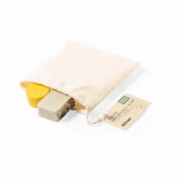 Two solid shampoo bars in a natural fabric bag, one yellow and one grey with black specks. The bag has a tag attached.