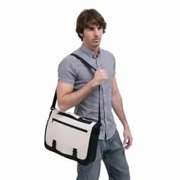 A messenger bag in cream and black is carried by a man wearing a grey shirt and jeans. The bag features a logo.
