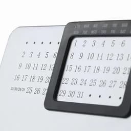A desk calendar featuring a black frame and numerical dates displayed in black and white.