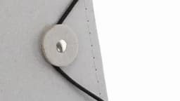 A grey notebook with a circular closure and a black elastic band, featuring stitched edges.