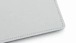 A grey leather product with a neat stitched edge, featuring a smooth surface and rounded corners.