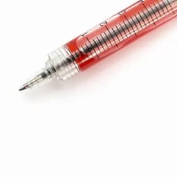 A red liquid-filled medical syringe with measurement markings and a silver tip.