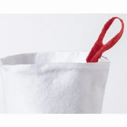 A white container with a red fabric handle peeking out from the top.