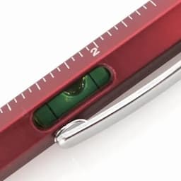 A red spirit level with a green bubble vial and a metal clip. The level features measurement markings.