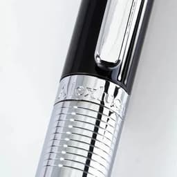 A pen featuring a sleek black body and a shiny chrome grip, with a clip and brand logo.