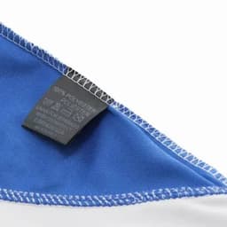 A blue and white fabric corner with visible stitching and a care label attached.
