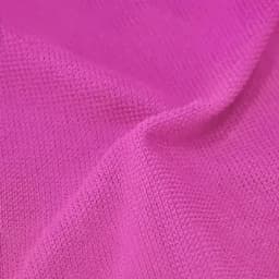 A close-up of a textured, bright pink gym towel featuring a subtle logo design.