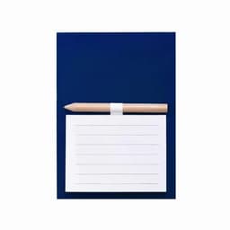 A navy notebook with a white lined page and a wooden pencil resting on top. The notebook has a simple design.