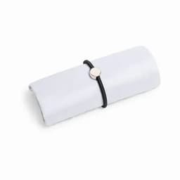 A rolled white cloth secured with a black elastic band and a metallic disc.