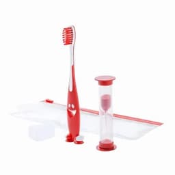 A red toothbrush with a smiling face design, an hourglass timer, and toothpaste tablets in a clear pouch.