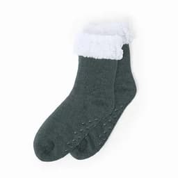 A pair of cosy green socks with a fluffy white cuff and non-slip grips on the soles.
