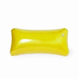 A bright yellow inflatable pillow with a smooth, glossy finish. It features a small hole for inflation.