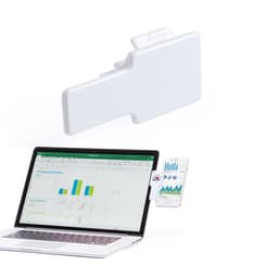 A white product positioned near a laptop displaying data graphs and charts on the screen, with a phone nearby.
