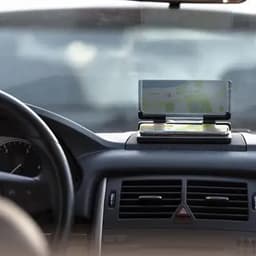 A car interior featuring a dashboard with a navigation device displayed, alongside a smartphone holder.